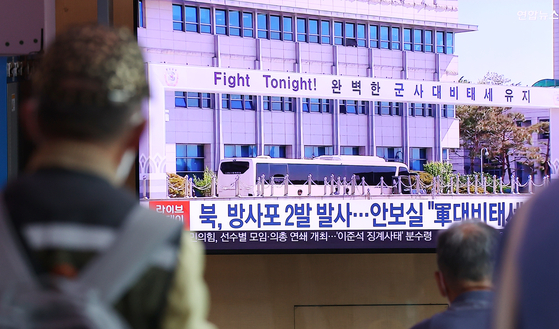 Passengers at Seoul Station in central Seoul on Monday morning watch a news broacast about artillery shorts fired by North Korea the previous evening. [YONHAP]