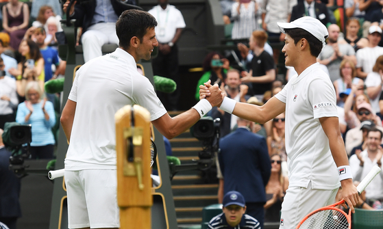 Serbia's Novak Djokovic greets Kwon Soon-woo, right, at the net after winning their men's first round singles match on day one of Wimbledon at the Center Court of the All England Lawn Tennis and Croquet Club in London on June 27. [EPA/YONHAP]