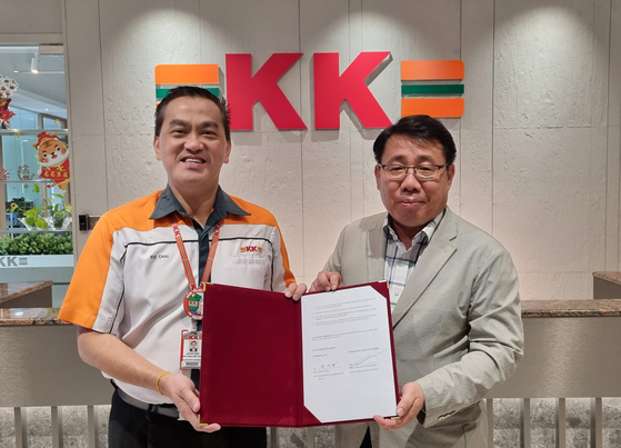 Jung Jae-hyung, right, representative of GS Retail's convenience store division, and Datuk Seri Dr. KK Chai, founder and chairman of KK Group, pose for a photo after signing a memorandum of understanding on July 9. [GS RETAIL]