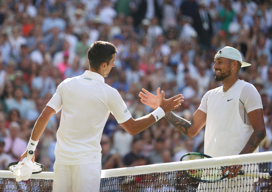 Novak Djokovic(왼쪽)이 일요일 런던 All England Lawn tennis & Croquet Court의 Center Court에서 열린 Djokovic과 Kyrgios 간의 남자 단식 결승에서 우승한 후 네트에서 Nick Kyrgios에게 경례를 하고 있습니다. [XINHUA/YONHAP]