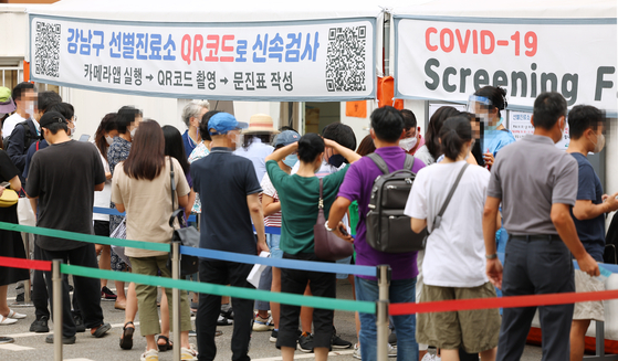 People queue to be tested for Covid-19 at a testing center in Gangnam District, southern Seoul, on Tuesday. [YONHAP] 