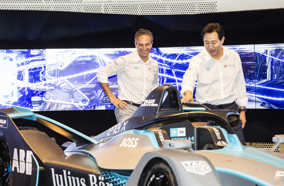Oh Se-hoon, right, mayor of Seoul, and Jamie Reigle, CEO of Formula E, take a look at the official race car, GEN2, at a press conference held at Dongdaemun Design Plaza in central Seoul on Tuesday. [FORMULA E KOREA]