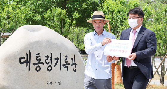 Lee Rae-jin, left, brother of murdered fisheries official Lee Dae-jin, walks with family attorney Kim Ki-yoon to submit a request for records on his brother's death held by the Presidential Archives in Sejong, central Korea on May 25. [YONHAP]