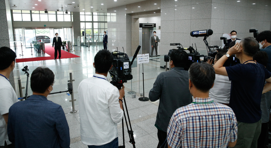 President Yoon Suk-yeol takes questions from reporters Tuesday morning at the presidential office in Yongsan, central Seoul, farther away from press than usual, resuming such “doorstepping” sessions just one day after they were suspended. [JOINT PRESS CORPS]