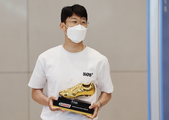 Son Heung-min pictured at Incheon International Airport holding the Premier League Golden Boot trophy in hand on May 24, wearing a NOS7 white t-shirt. [YONHAP]