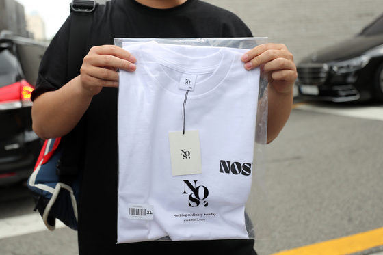 A fan holds up a NOS7 t-shirt on June 17. [NEWS1]