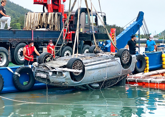 A vehicle belonging to the family of missing child Cho Yoo-na is lifted out of the water near Songgok Harbor in Wando, South Jeolla on Wednesday morning. [YONHAP]