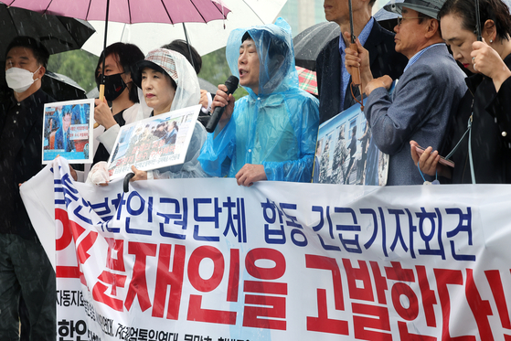 North Korean defectors and human rights' groups hold a press conference in the rain outside the National Assembly in southern Seoul on Wedneday in response to the release of photos showing the fishermen's repatriation. [YONHAP] 