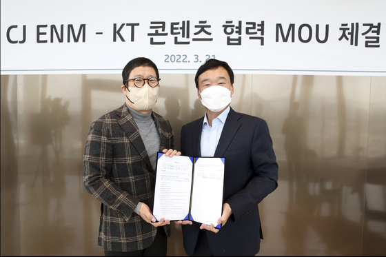 Executives from CJ ENM and KT pose for photos after signing an agreement on production and distribution in March. [KT]