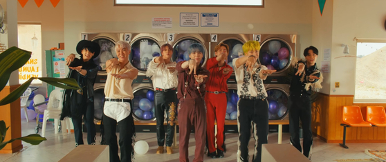 A scene from BTS's music video for "Permission to Dance" (2021) shows members incorporate international sign language into their choreography. [BIGHIT MUSIC]