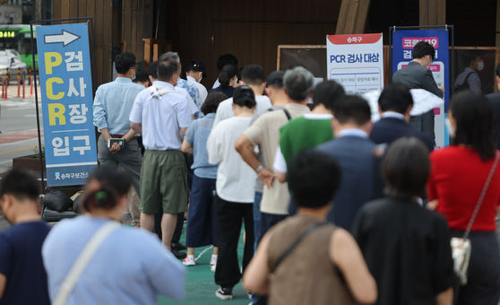 People wait in line to get tested for Covid-19 at a testing center in Songpa District, southern Seoul, on Monday. [YONHAP]
