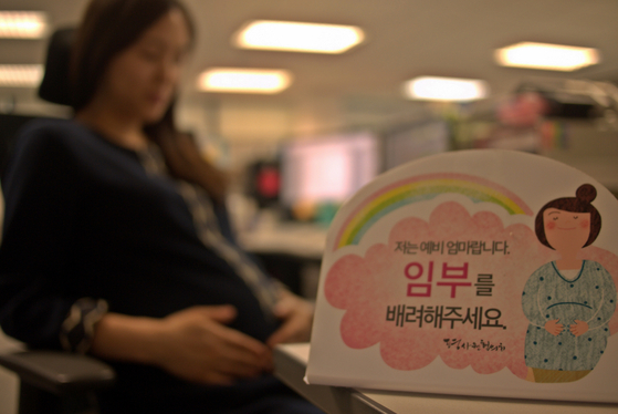 A sign reads, "I am an expectant mother taking a break" on the desk of an employee of Samsung Fire and Marine Insurance company in a file photo. [JOONGANG PHOTO] 