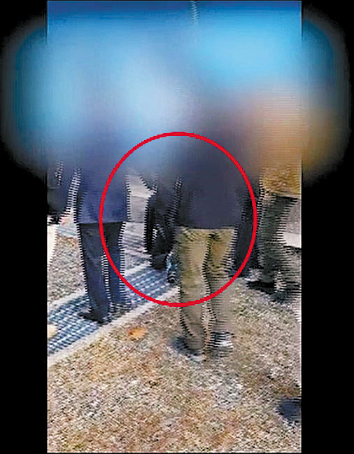 In a video released by the Unification Ministry on Monday, the first of the two North Korean fishermen to be repatriated via Panmunjom Nov. 7, 2019 can be seen kneeling on a metal grate close to the Military Demarcation Line before South Korean officials drag him into the North. [MINISTRY OF UNIFICATION]