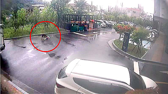 CCTV footage shows an eight-year-old child being bitten by a dog in an apartment complex parking lot in Ulsan, South Gyeongsang, on July 11. [SCREEN CAPTURE]