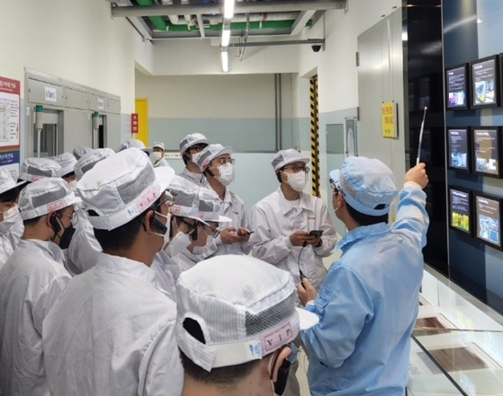 A Samsung Electro-Mechanics employee explains the manufacturing process of a semiconductor package substrate to journalists on Thursday at the company's production site in Gangseo District of western Busan. [SAMSUNG ELECTRO-MECHANICS]