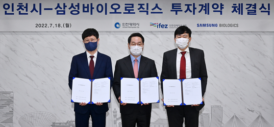 Incheon mayor Yoo Jeong-bok, center, and Samsung Biologics CEO John Rim, right, stand for a photo after signing a deal to buy a 357,366-square-meter site in Songdo for 426 billion won ($324 million). [SAMSUNG BIOLOGICS] 
