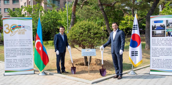 Azerbaijan Ambassador to Korea Ramzi Teymurov, right, and head of the Yongsan DIstrict Office Seong Jang-hyun, left, plant a tree at the Singye Historical Park in Yongsan to celebrate the 30th anniversary of Azerbaijan-Korea relations on May 12. [YONHAP] 