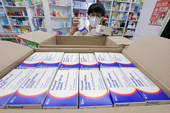 A pharmacist displays a case of Paxlovid, Covid-19 treatment pills developed by Pfizer Inc., at a drugstore in Seoul on Wednesday. [NEWS1]