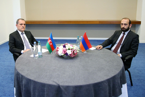 This handout picture taken and released by Georgian Ministry of Foreign Affairs on July 16 shows Foreign Minister of Azerbaijan Jeyhun Bayramov, left, and Armenian Foreign Minister Ararat Mirzoyan, right, looking on during a meeting in Tbilisi for the first bilateral talks between the two Caucasus nations since the 2020 war for control of the disputed Nagorno-Karabakh region. [GEORGIAN MINISTRY OF FOREIGN AFFAIRS/AFP/YONHAP] 