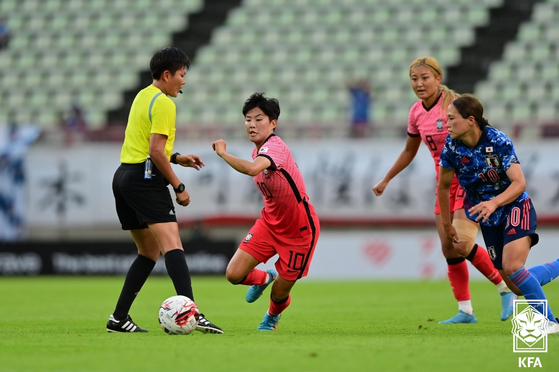 Ji So-yun, second from left, dribbles the ball during a 2022 EAFF E-1 Football Championship match against Japan at Kashima Soccer Stadium in Kashima, Japan on Tuesday. [KFA/YONHAP]