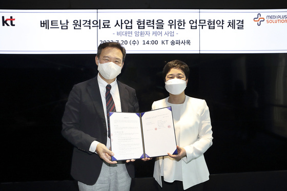 Yim Seung-hyouk, left, head of KT's digital and biohealth business unit, poses with Bae Yoon-jung, Medi Plus Solution CEO, during a signing ceremony held in Songpa District, southern Seoul, Wednesday. [KT]