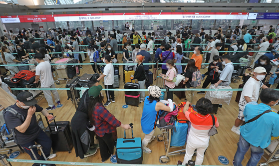 International travelers wait in a long line to check their baggage at Incheon International Airport on Sunday. Incheon International Airport Corporation estimates about 86,000 passengers per day will use the airport from July 22 until Aug. 10, the summer high season, seven times more than last year.   [NEWS1]