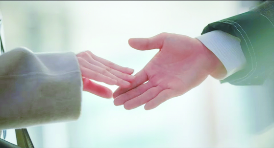 Woo, like many others with ASD, is sensitive to touch, and makes minimal contact with others physically, as in this scene when she shakes hands with her colleague. [ASTORY]