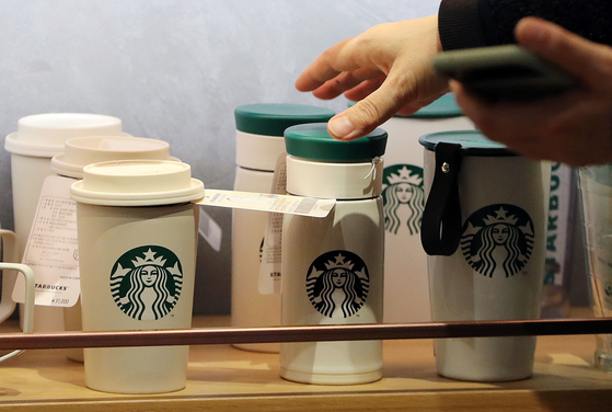 A customer grabs a Starbucks tumbler at a store in Seoul. [NEWS1]