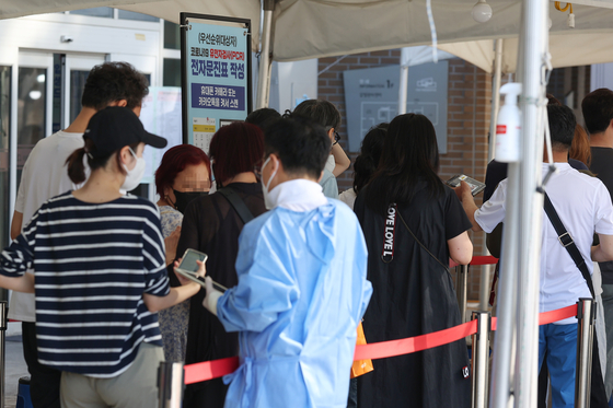 People wait in line to gest tested for Covid-19 at a testing center in Mapo DIstrict, western Seoul, Monday. [YONHAP]