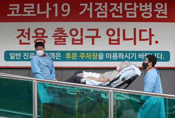 Medical workers move a Covid-19 patient at Hyemin Hospital in Gwangjin District, eastern Seoul, on Tuesday. [YONHAP]