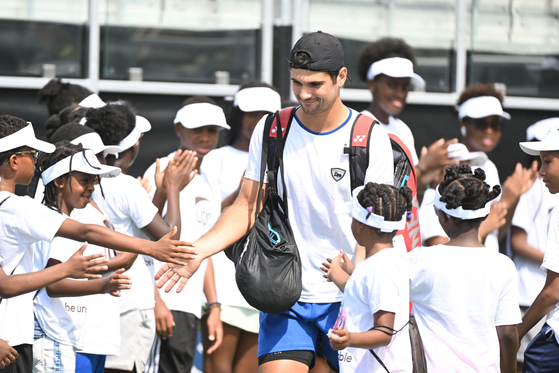 Marcos Giron of the United States is greeted by young fans before his match against Kwon Soon-woo on Day One of the Atlanta Open at Atlantic Station in Atlanta on Monday. [AFP/YONHAP]