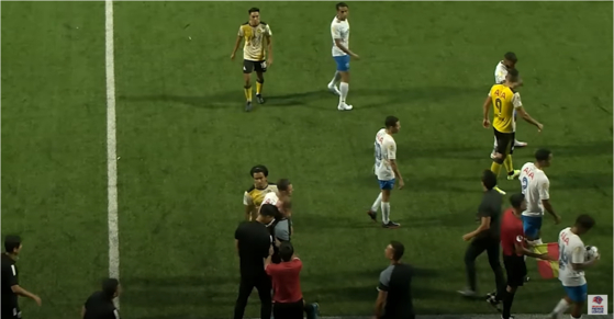 Players watch on as Lion City Sailors manager Kim Do-hoon, bottom left in black, appears to headbutt Tampines Rovers assistant coach Mustafic Fahrudin on the sidelines of a game on Sunday in a still from the official match report video shared by the Singapore Premier League on YouTube. [SCREEN CAPTURE]