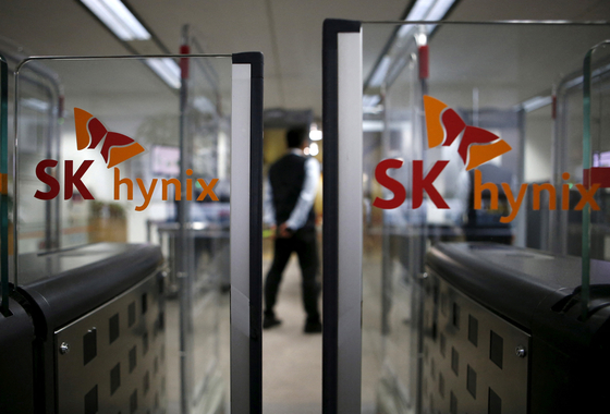 The logos of SK Hynix are seen as a security personnel stands guard at its office in Seongnam, Gyeonggi. [REUTERS]