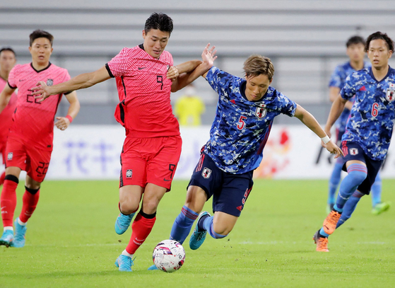 Cho Gue-sung, left, and Japan's Shinnosuke Hatanaka fight for the ball during a match between Japan and Korea at the EAFF E-1 Football Championship in Toyota, Japan on Wednesday evening. [AFP/YONHAP]