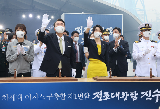President Yoon Suk-yeol, center left, and first lady Kim Keon-hee, center right, wave during a launch ceremony for the Jeongjo the Great Aegis destroyer at the Hyundai Heavy Industries shipyard in Ulsan Thursday. [JOINT PRESS CORPS]