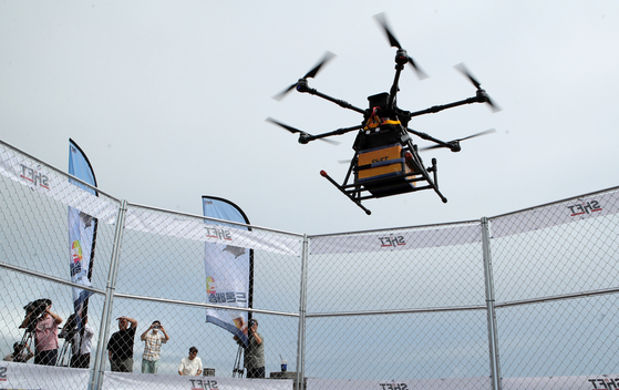 A drone delivers food near Mangsang beach in Donghae, Gangwon, on Thursday. The Gangwon Provincial Office and Donghae city government started a pilot delivery service using autonomous drones that make deliveries from stores at the beach to the Donghae Mangsang Auto Camping Resort on Thursday. [YONHAP]