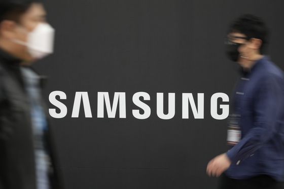 Visitors walk past the logo of Samsung Electronics at a semiconductor exhibition in Seoul. [AP]