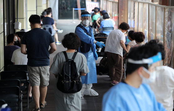People wait to get tested for Covid-19 at a testing center in Songpa District, western Seoul, on Friday. [NEWS1]