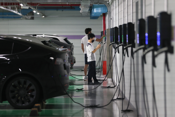 Electric vehicle owners charge their cars at a station located inside a parking lot in a building in southern Seoul on Sunday. According to the Ministry of Land, Infrastructure and Transport, EVs were 1.2 percent of all cars in Korea as of June, breaking the 1-percent mark for the first time. The number of registered EVs in Korea was 298,633, 72 percent more than June 2021. [YONHAP]