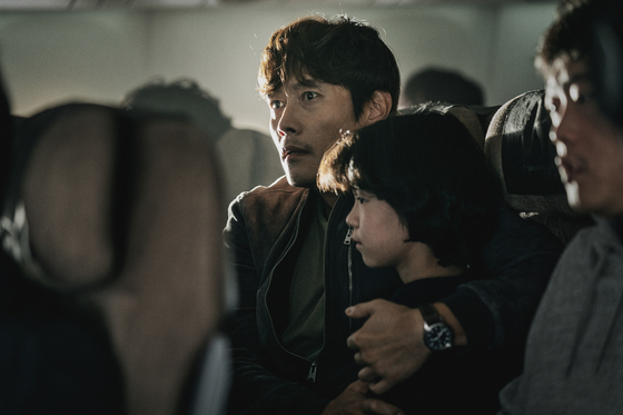 Lee Byung-hun as a former pilot and the father to a young daughter who boards a plane to Hawaii but instead faces unanticipated terror caused by a mysterious passenger, portrayed by Yim Si-wan in "Emergency Declaration" (2022). [SHOWBOX]