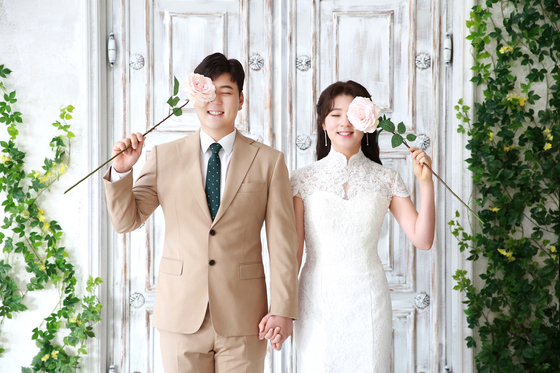 Golfers Ham Jeong-woo and Kang Ye-rin pose in a pre-wedding ceremony photo released on March 17. The couple got married two days after in a wedding hall in Cheonan, South Chungcheong. [YONHAP] 