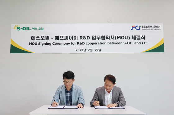 Lee Jeung-ik, left, vice president of S-Oil, and Lee Tae-won, FCI CEO, sign a memorandum of understanding at FCI headquarters in Daejeon on Friday. [S-OIL]