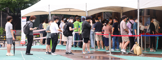 People wait in line to get tested at a testing center in Songpa District, southern Seoul, Monday. [NEWS1]