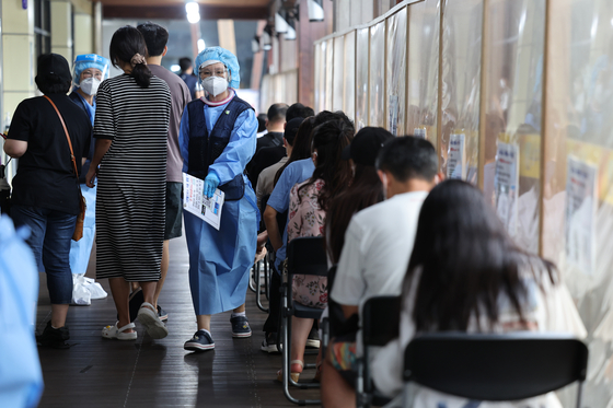 People wait to be tested at a Covid-19 testing center at the Songpa District Public Medical Center in southern Seoul on Tuesday. [YONHAP]