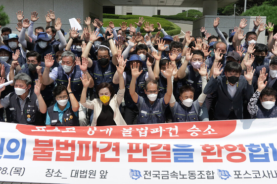 Members of the Korean Metal Workers’ Union celebrate the Supreme Court's decision that ordered Posco to hire its 55 subcontracted workers as regular employees in front of the court in Seocho District, southern Seoul, on July 28. The banner says it welcomes the court's ruling. [KOREAN METAL WORKERS' UNION] 
