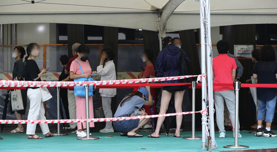 People wait in line to get tested for Covid-19 at a testing center in Songpa District, southern Seoul, on Wednesday. [NEWS1]