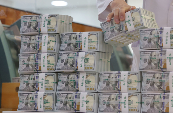 An employee from Hana Bank's department tasked with identifying counterfeit bills organizes dollars at the bank branch in central Seoul on July 5. [YONHAP]