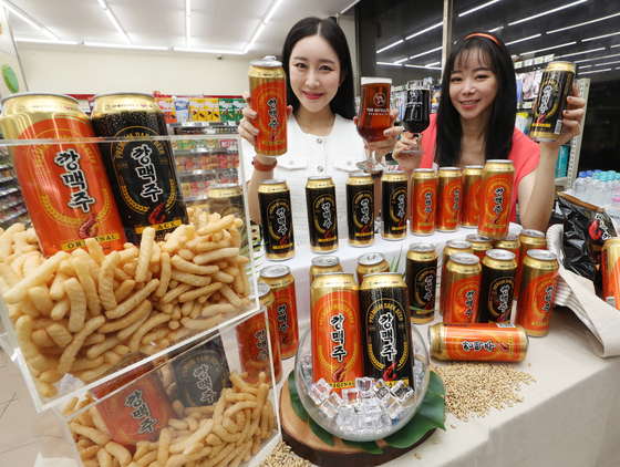Models pose with Kkang beers at a 7-Eleven branch in central Seoul. Nongshim, the maker of Saewookkang, a shrimp-flavored chip snack, collaborated with Satellite Brewing to introduce the craft beers. [NEWS1]