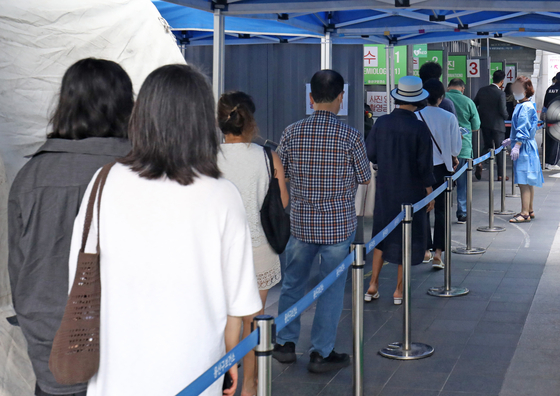 People wait in line to get tested for Covid-19 at a testing center in Yongsan District, central Seoul, Thursday. [NEWS1]