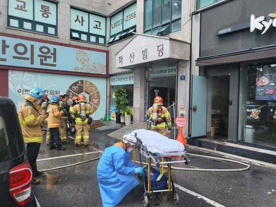 Firefighters prepare to enter a building in Icheon, Gyeonggi, where a hospital on the fourth floor caught fire Friday morning. [GYEONGGI DISASTER AND SAFETY HEADQUARTERS]